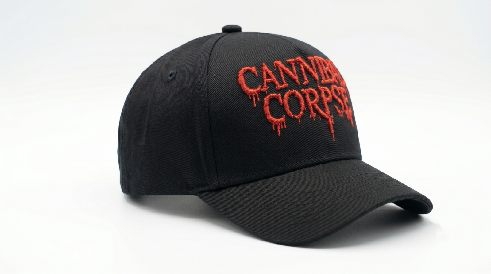 CannibalCorpse-D.png: Gorra negra Cannibal Corpse visera curva, ángulo 3/4 hacia la derecha, destacando relieve 3D del bordado rojo